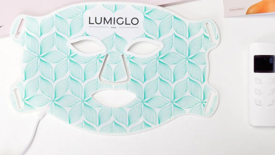Lumiglo Pro V2 LED face mask laid flat next to its controller